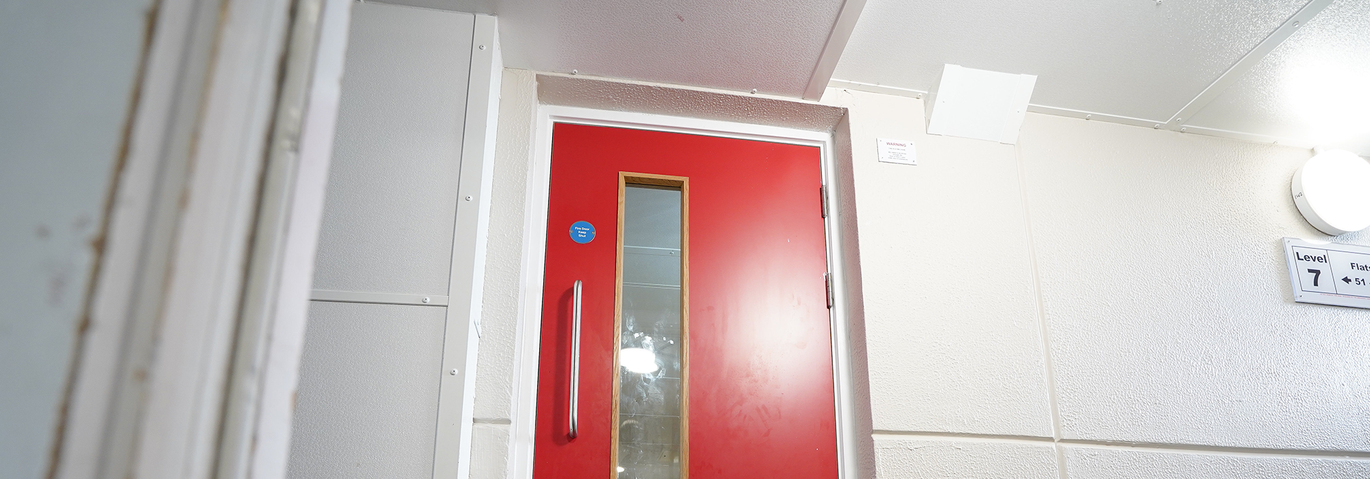 red fire door in a residential block corridor