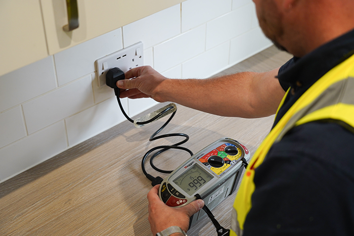 operative in high vis testing an electrical outlet