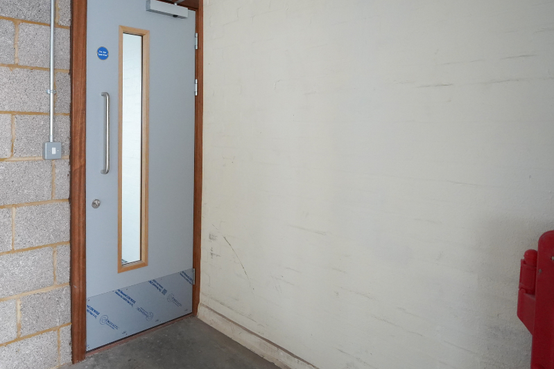 Fire door, brick wall, red fire extingusher